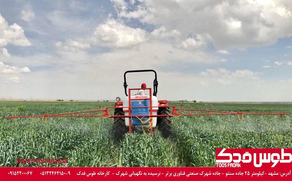 Agricultural canvas sprayer mounted on the back of a tractor